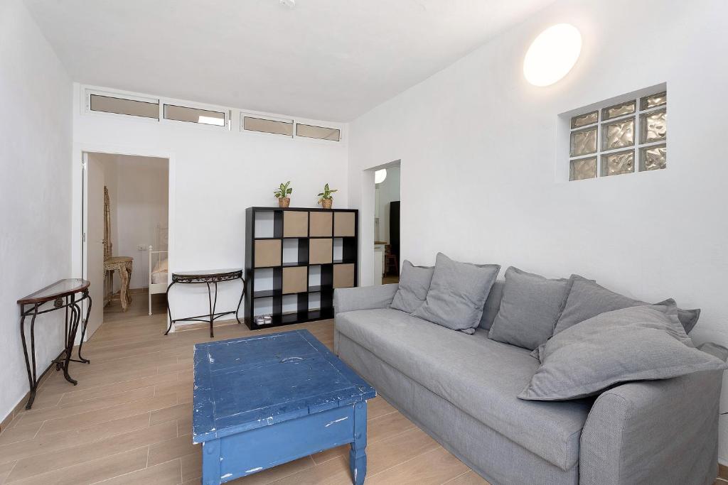 ein Wohnzimmer mit einem grauen Sofa und einem Tisch in der Unterkunft Apartamento Doris in Güímar