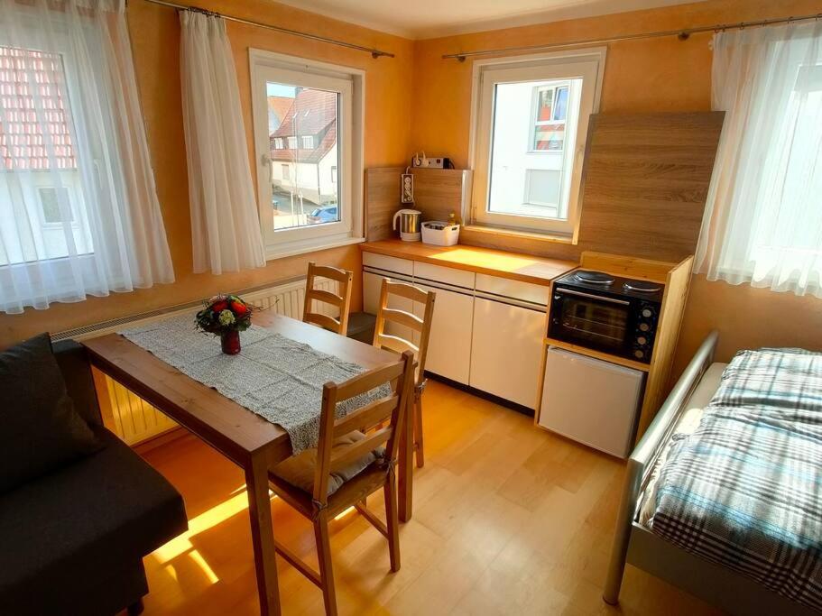 a small kitchen with a table and a bed at zentrale & ruhige Ferienwohnung in Mössingen