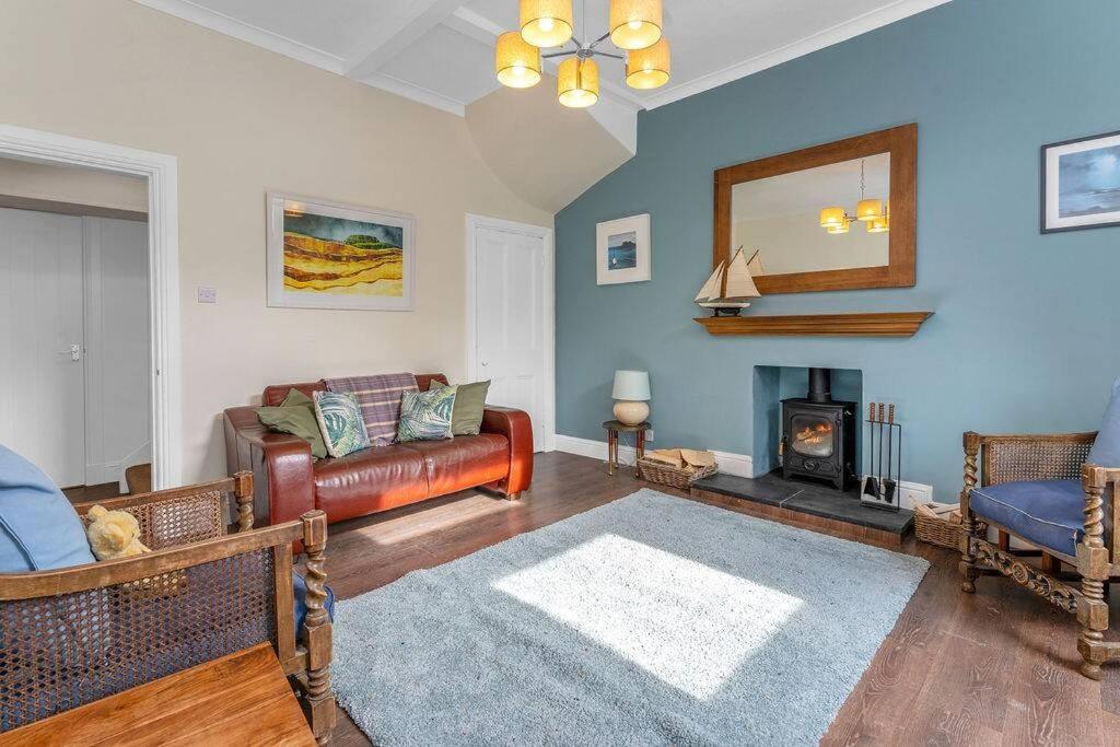 - un salon avec un canapé et une cheminée dans l'établissement Stylish country home near East Linton and Edinburgh, à Whittingehame