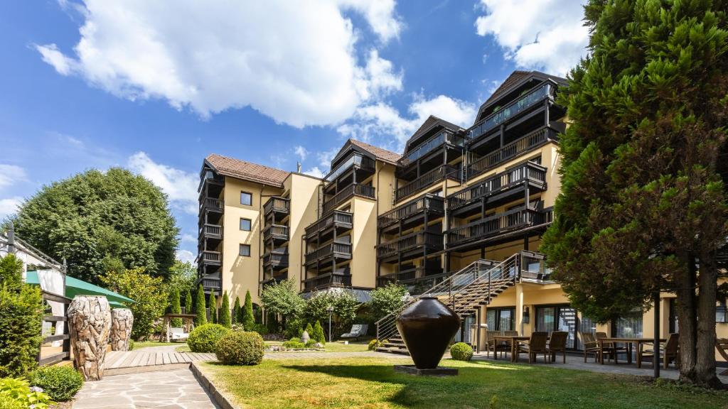 ein großes Apartmenthaus mit einem Garten davor in der Unterkunft Parkhotel Luise Bad Herrenalb in Bad Herrenalb