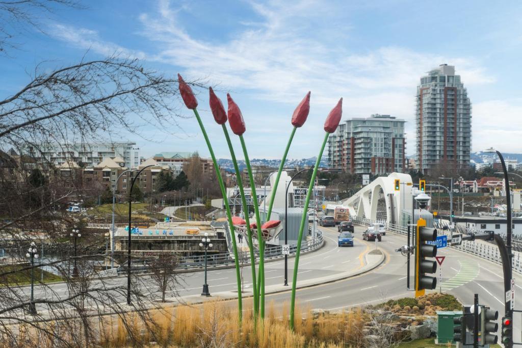 a city with red flowers in front of a highway at Bridge View Suite by Iris Properties! in Victoria