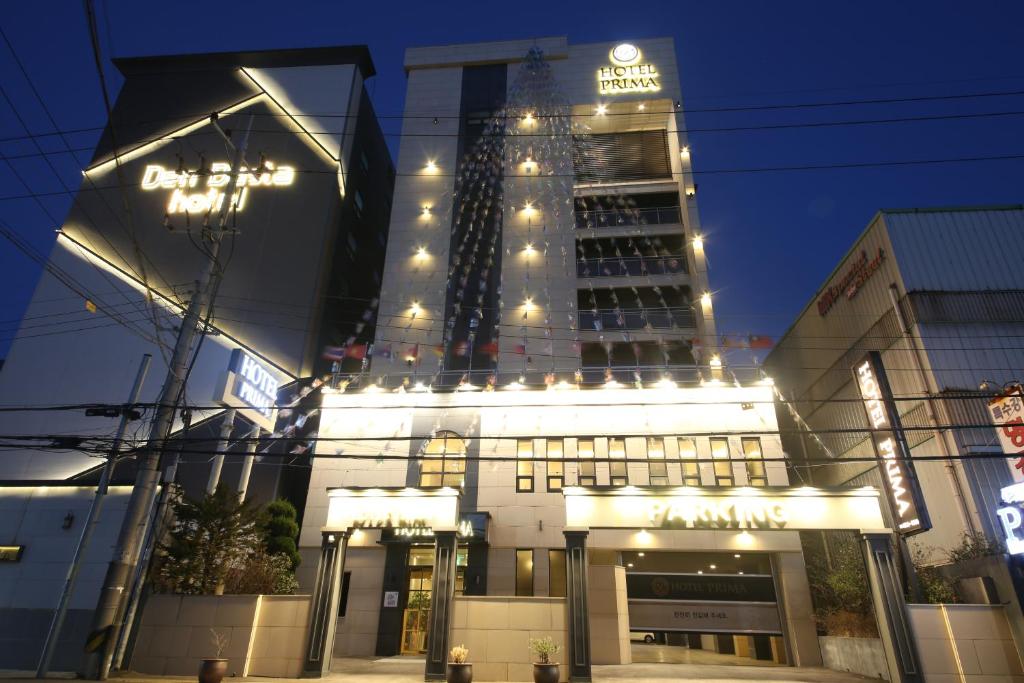 釜山的住宿－Hotel Prima Busan，一座高大的建筑,晚上有灯