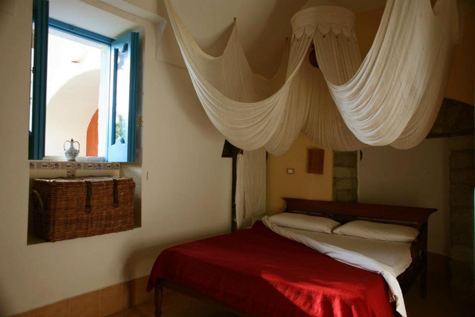 Schlafzimmer mit einem Bett und einem Fenster mit Vorhängen in der Unterkunft Dimora Coloniale B&B in Ischia