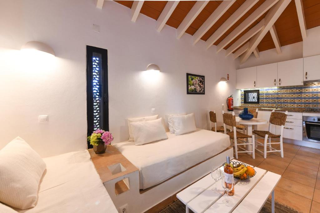 a living room with a bed and a kitchen at Pedras D'el Rei in Tavira