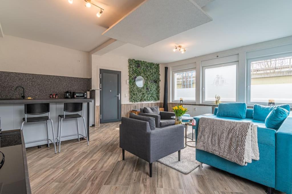 ein Wohnzimmer mit einem blauen Sofa und einer Küche in der Unterkunft Gemütliches Apartment in Neuwied in Neuwied