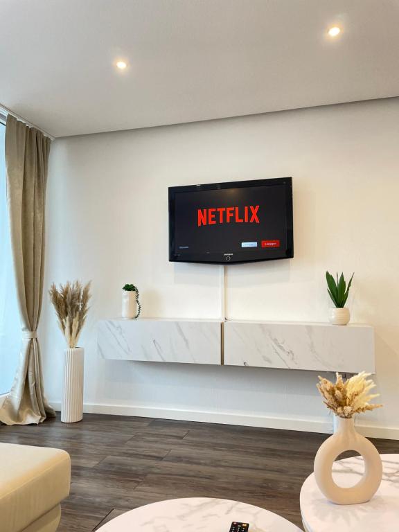 a television on a wall in a living room at REGENCY Apartments - Stylische zentrale 50m2 Wohnung mit Balkon, Wasserblick und Netflix in Hannover
