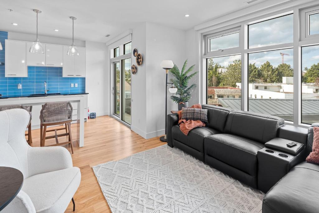 sala de estar con sofá negro y cocina en West Bay Topaz by Iris Properties!, en Victoria
