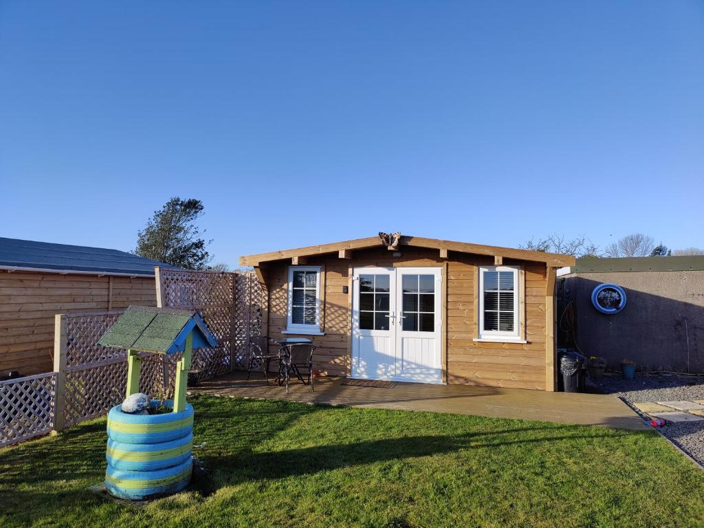 una pequeña casa con parque infantil en el patio en The Cabin en Millom