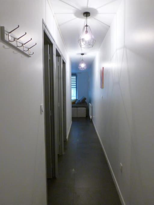 a hallway with white walls and a long hallway at Appart de style centre Sedan 2E in Sedan