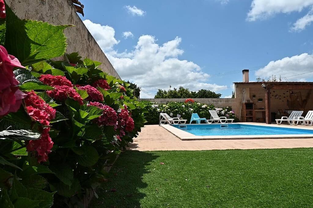 un patio trasero con piscina y flores en Casinhas Escondidinho, 