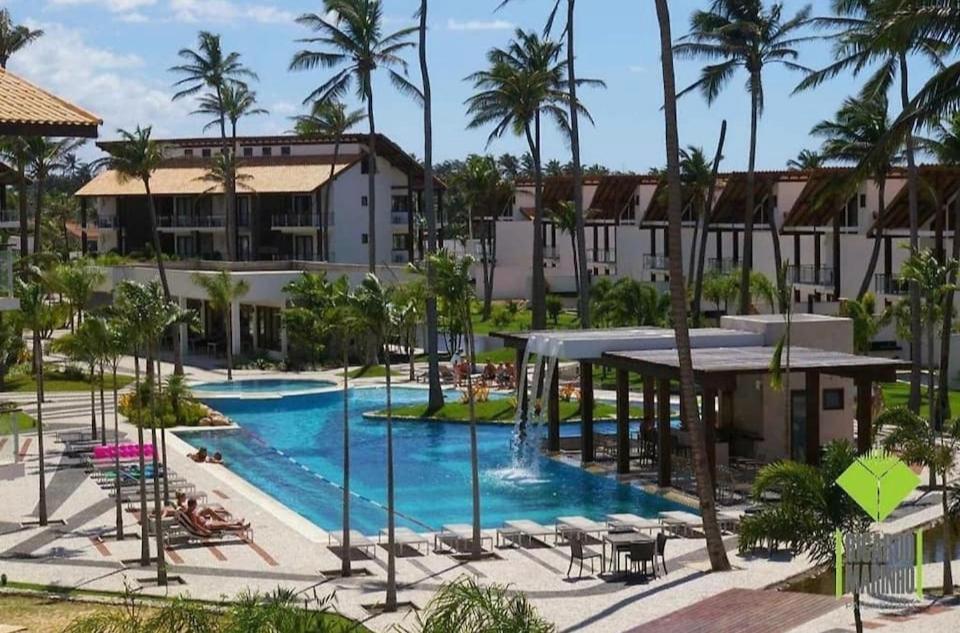 uma vista aérea de uma piscina de resort com palmeiras em Taiba Beach Resort - Apt Duplex Novo em Taíba