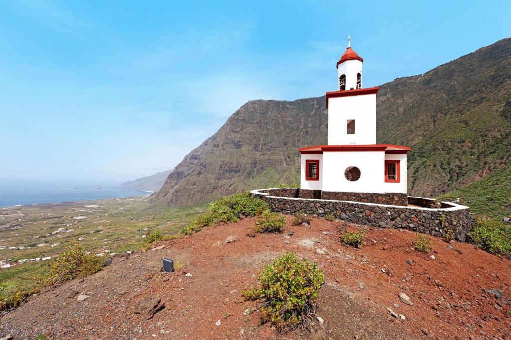 a lighthouse on top of a hill with the ocean at Villa Luisa en Frontera in Tigaday