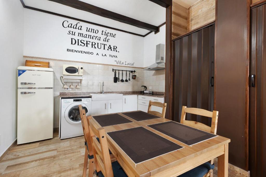 a kitchen with a wooden table and a washing machine at Villa Luisa en Frontera in Tigaday