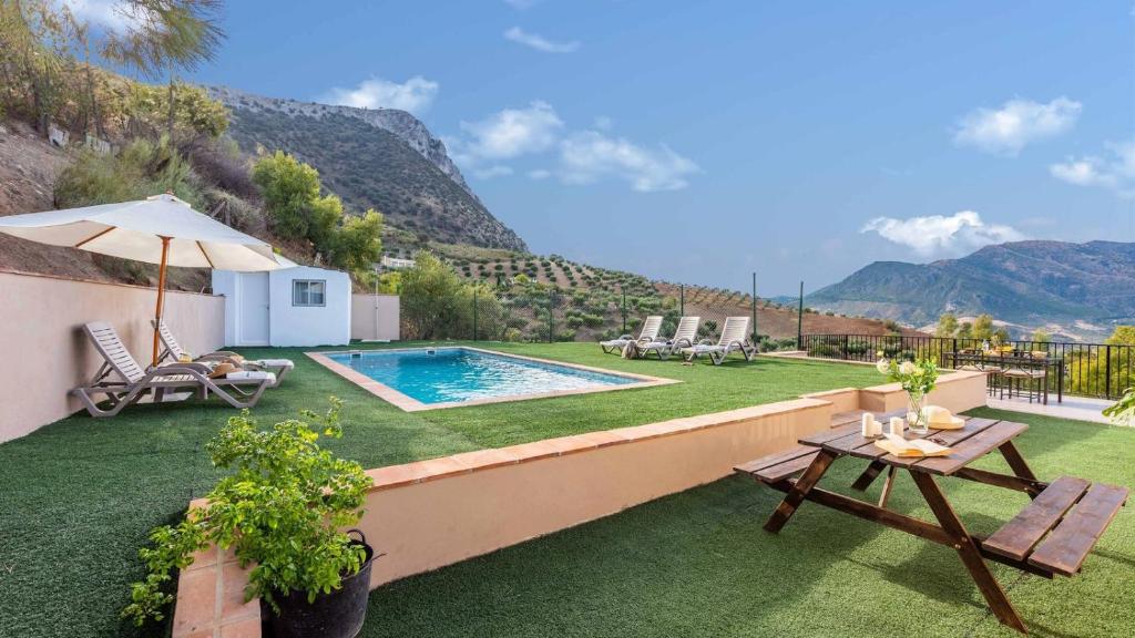 einen Hinterhof mit einem Pool sowie einem Tisch und Stühlen in der Unterkunft Fuente Barrera El Gastor by Ruralidays in El Gastor