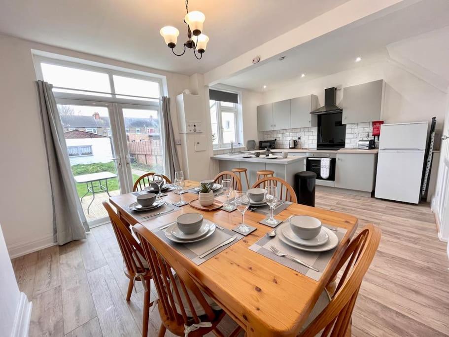 a kitchen and dining room with a wooden table and chairs at City Haven Luxurious 3-Bed Retreat in Portsmouth