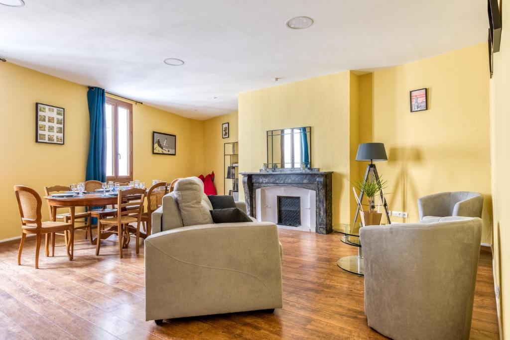 uma sala de estar com uma mesa e cadeiras e uma lareira em Maison du capitole em Narbonne