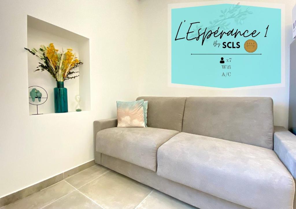 - un canapé dans le salon avec une photo sur le mur dans l'établissement L'Esperance By SCLS Locations, à Cannes