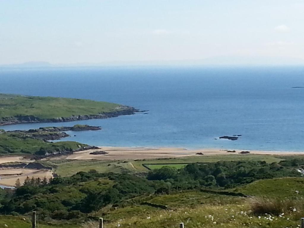 a bird flying over a beach in the ocean at Two bed bungalow with sunroom and stunning views in Killybegs