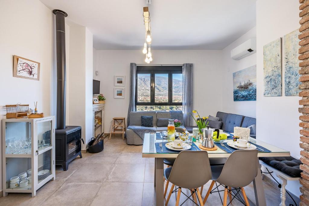 a kitchen and living room with a table and chairs at La Parva - Casa rural Eralta in Dúrcal