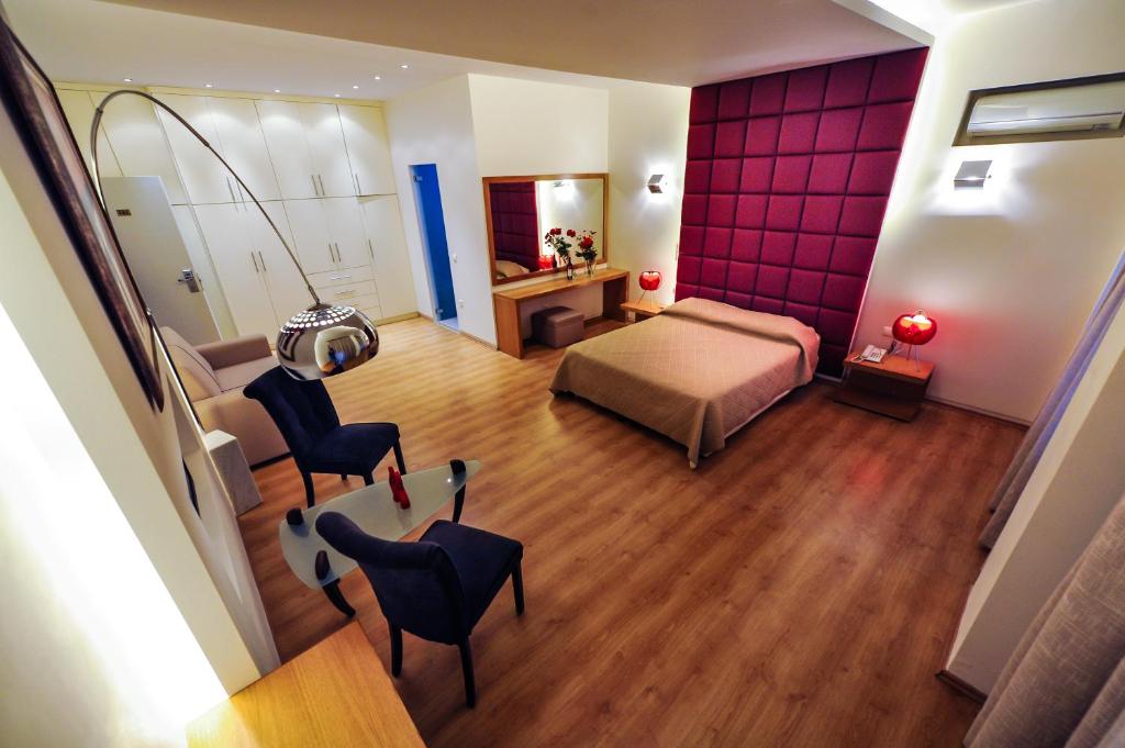 um quarto com uma cama, uma mesa e cadeiras em Kleopatra Inn em Messini