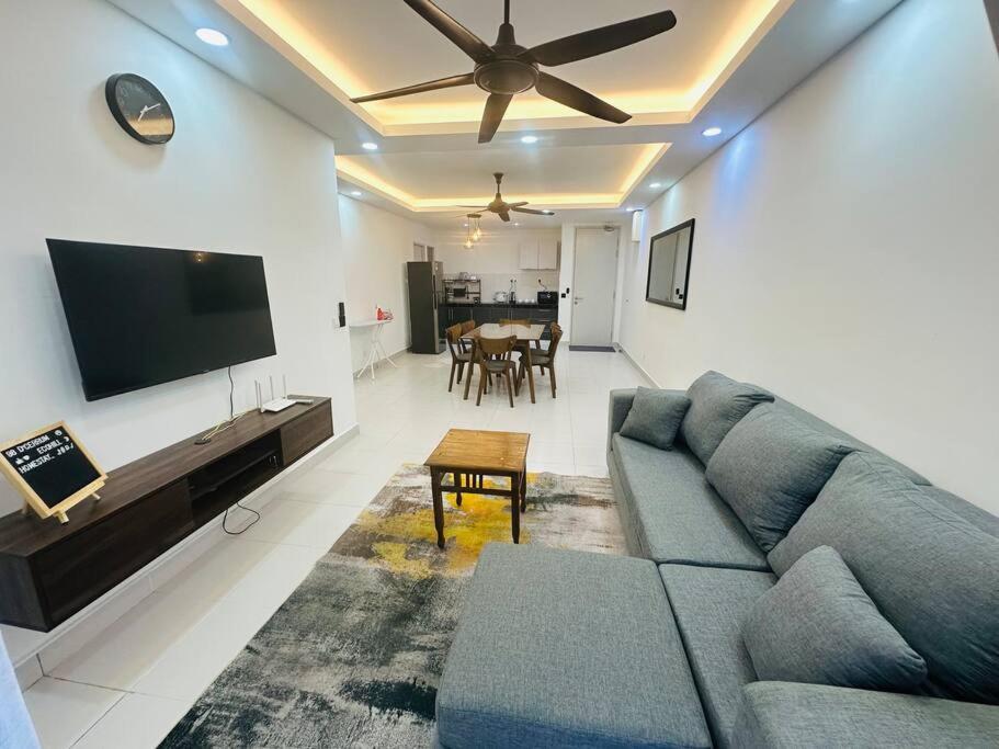 sala de estar con sofá y TV de pantalla plana en Homestay Ecohill Semenyih, en Semenyih