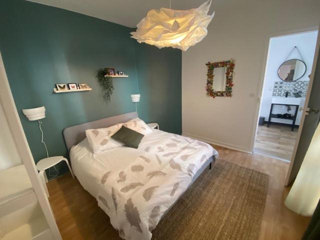 1 dormitorio con cama y lámpara de araña en appartement hyper centre ville, en Arras