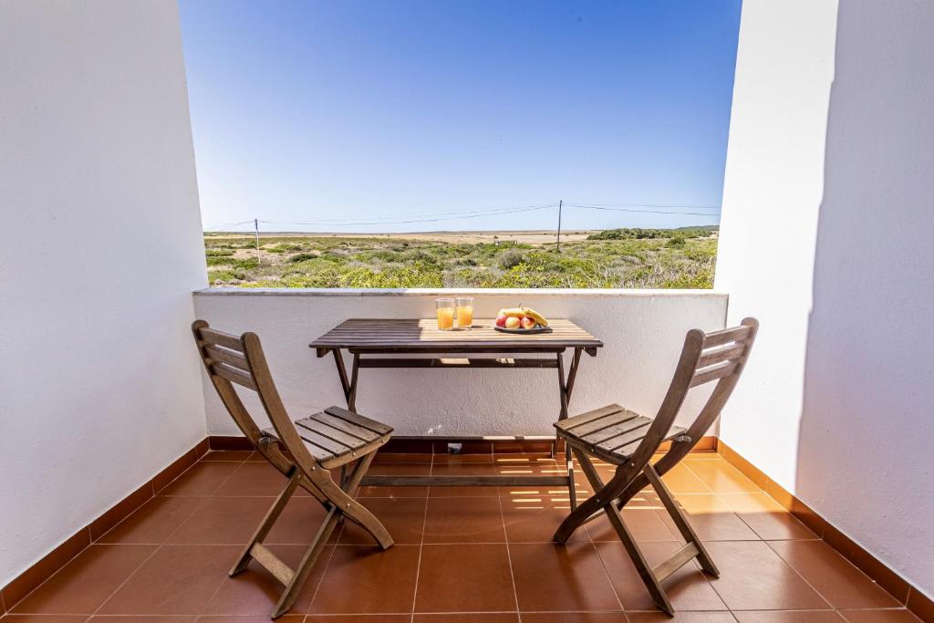 een klein balkon met een tafel en 2 stoelen bij Branco in Sagres