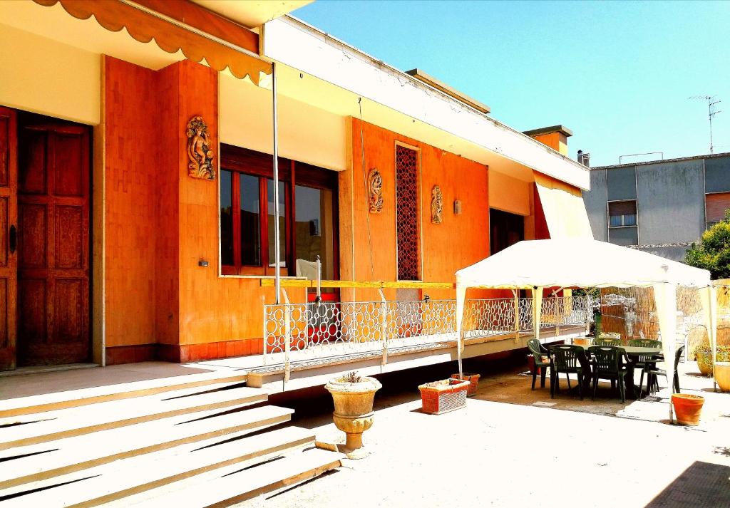 een gebouw met een veranda met een tafel en een paraplu bij Villetta Hydro 3 in Bagnolo del Salento