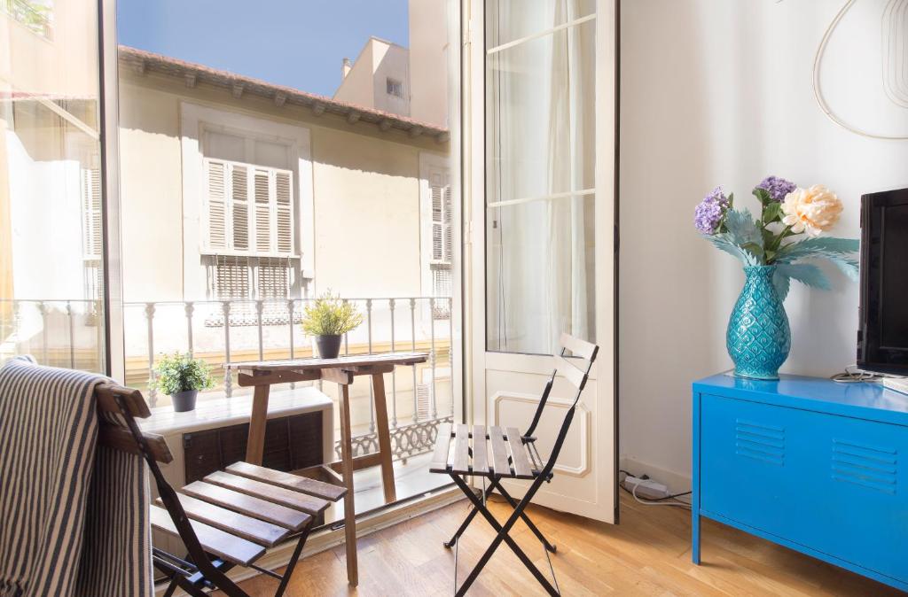 um quarto com uma mesa e cadeiras e uma janela em City Centre TEATRO em Málaga