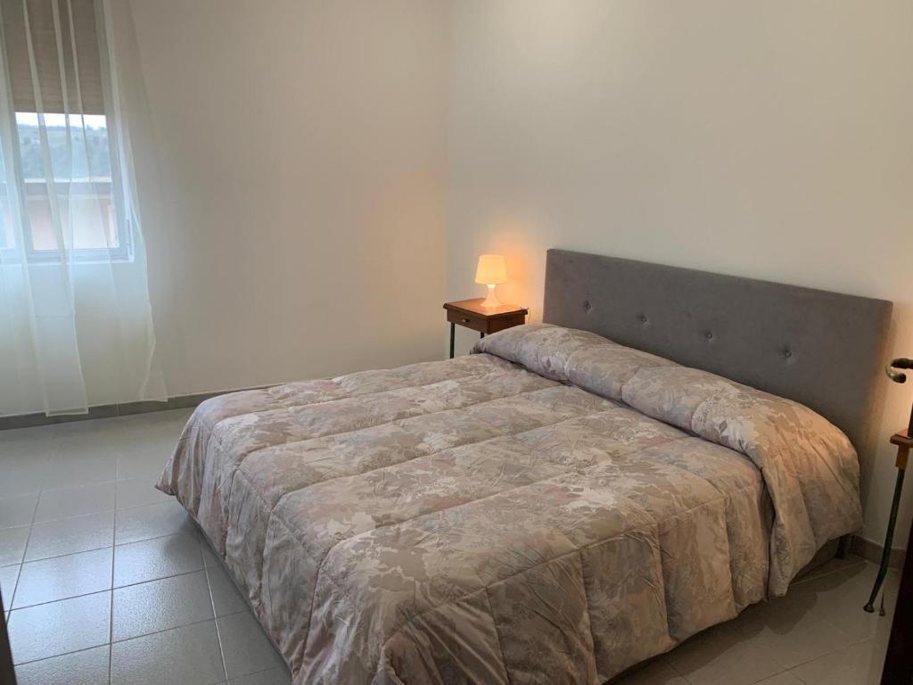 um quarto com uma cama e um candeeiro sobre uma mesa em Casetta Genneria em Seùlo