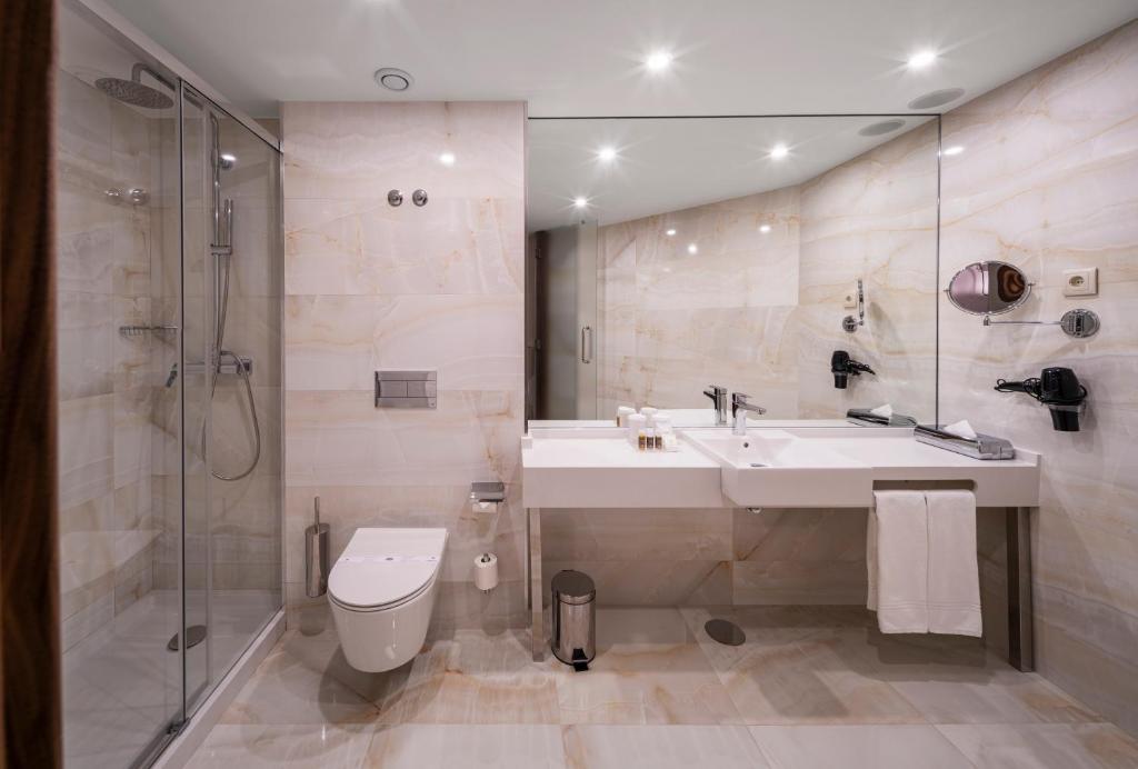 a bathroom with a sink and a shower and a toilet at TURIM Oporto Hotel in Porto