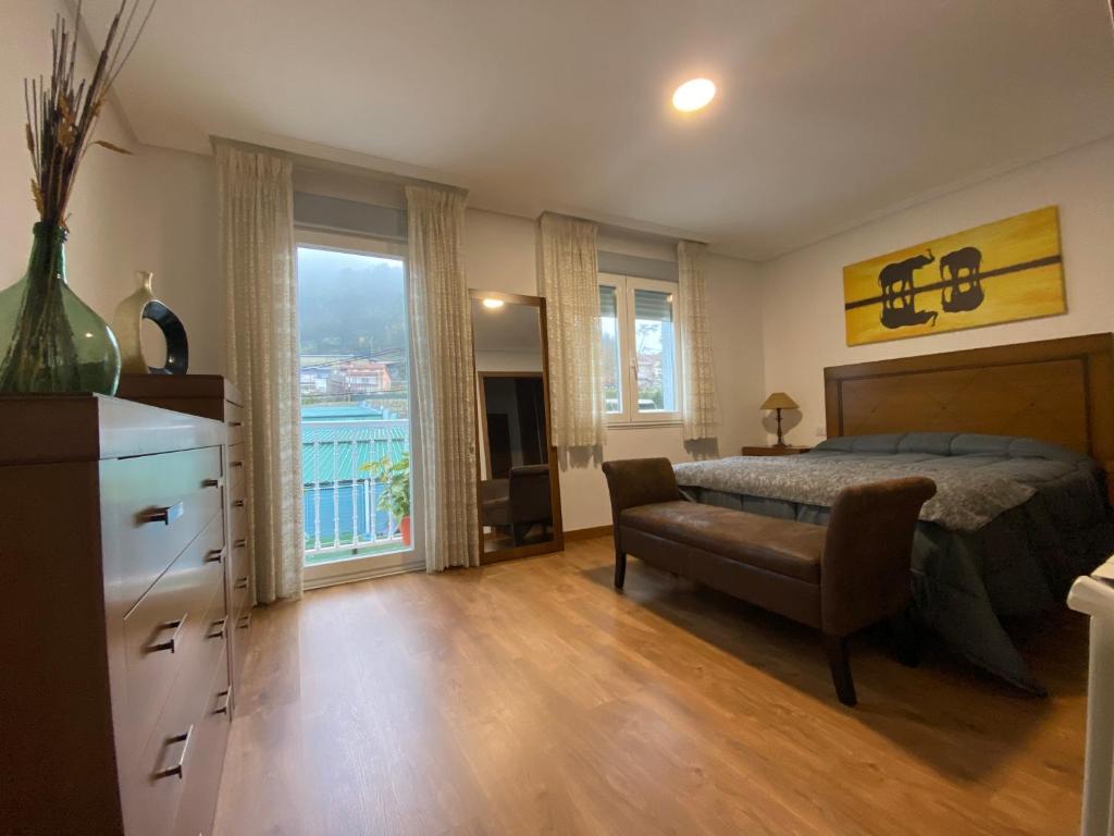 1 dormitorio con cama, escritorio y silla en AS REGATEIRAS casa próxima a las termas en Ourense