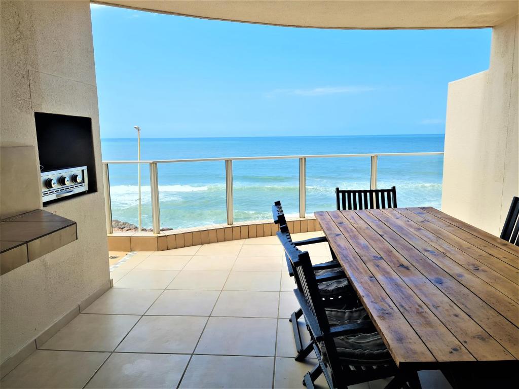 Un comedor con mesa y vista al mar. en Santorini 203A, en Margate