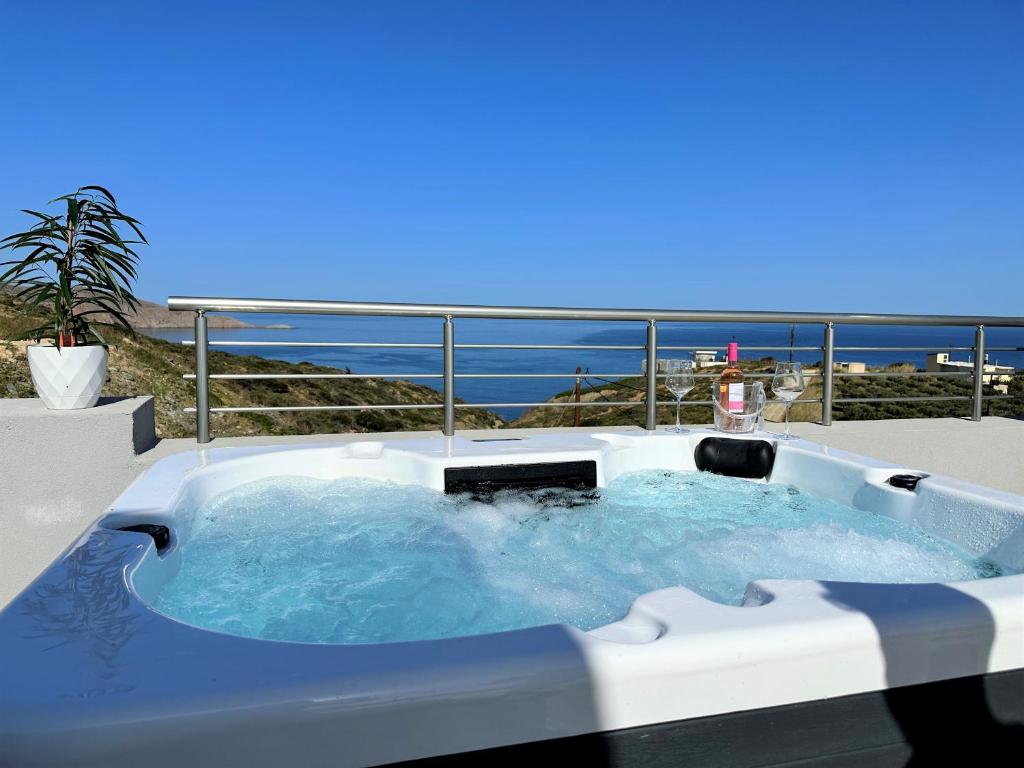 a hot tub with the ocean in the background at Yamina Rooftop Residence in Agia Pelagia