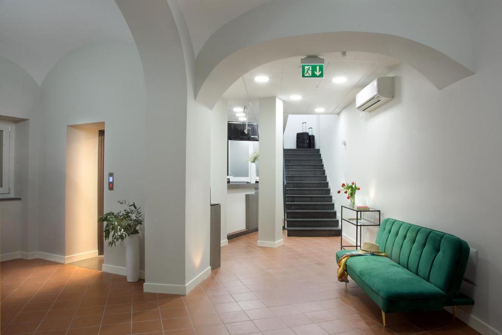 un corridoio con divano verde e scala di Palazzo Sant'Antonio a Napoli