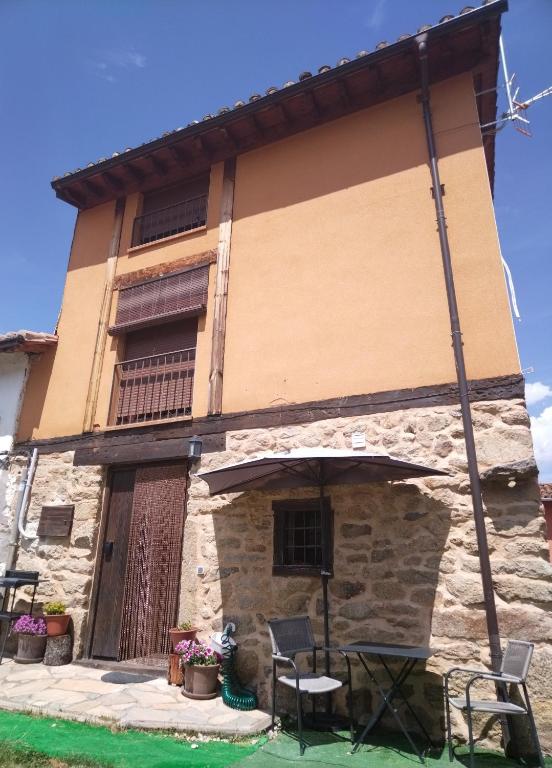 a building with a table and chairs in front of it at Casa Quimera in Gilgarcía