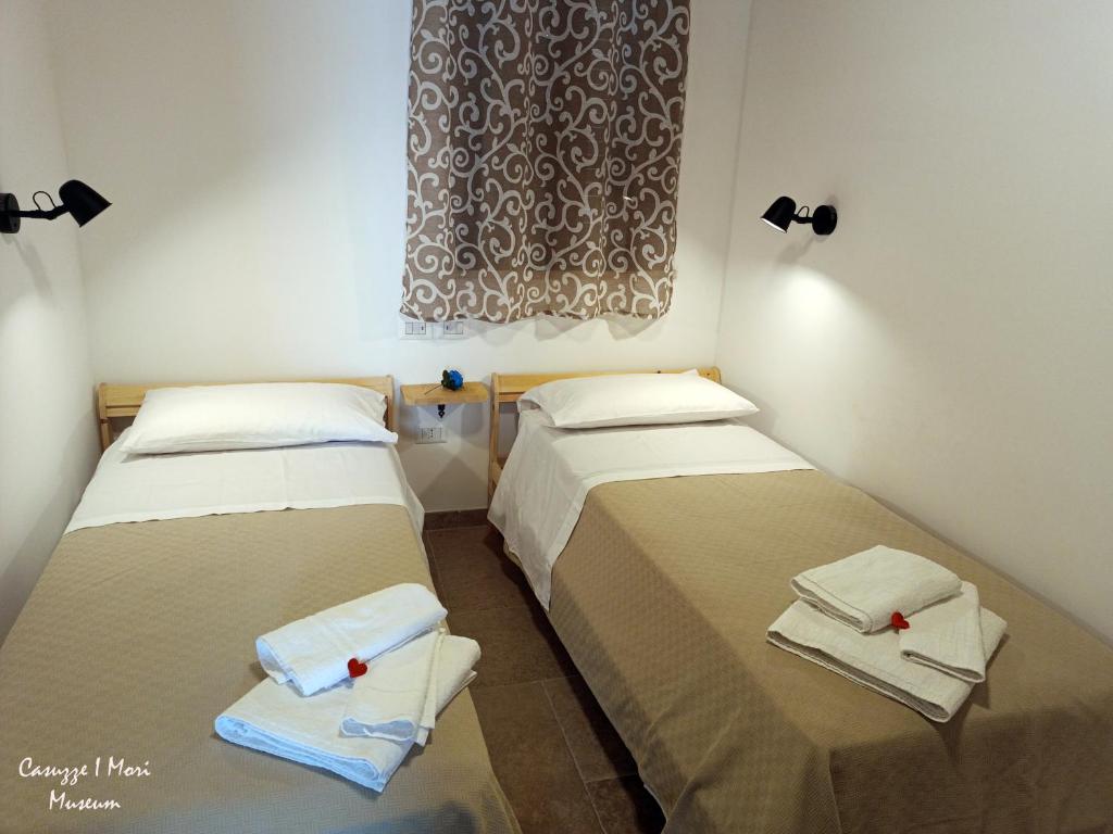 dos camas sentadas una al lado de la otra en una habitación en Casuzze I Mori Museum en Marzamemi
