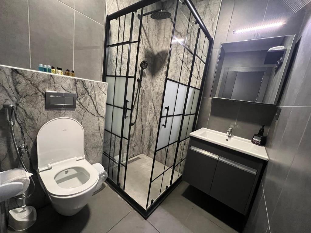 a bathroom with a toilet and a shower and a sink at Marina Green Suite & Residence in Trabzon
