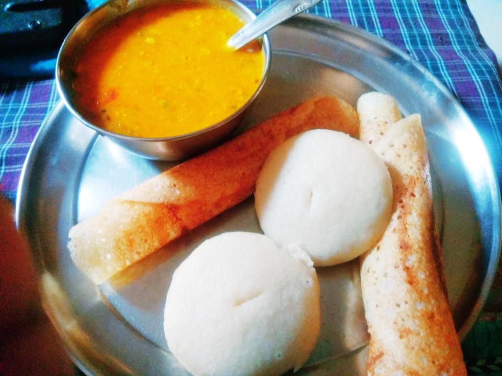 un plato de comida con pan y un tazón de sopa en Shri Homes, en Varanasi