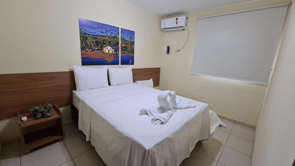 a small room with a bed with white sheets at Arena Carneiros Hotel by AFT in Tamandaré