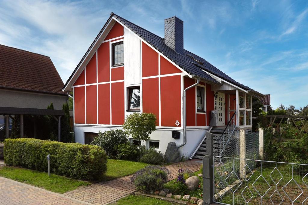 a red and white house with a yard at Ferienwohnung Damerow in Zinnowitz