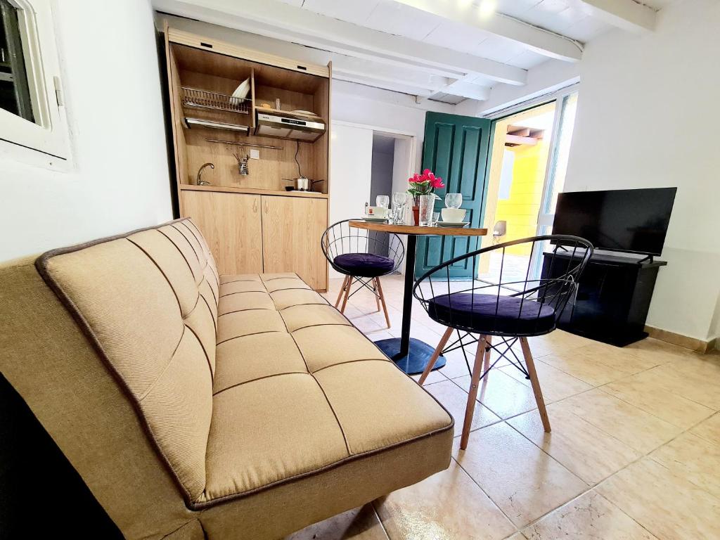 un soggiorno con divano e tavolo con sedie di Piccolo Modern Suites Old Town a Città di Rodi
