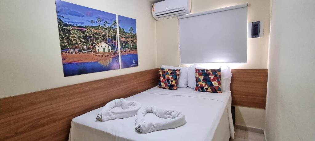 two beds in a room with a picture on the wall at Arena Carneiros Hotel by AFT in Tamandaré