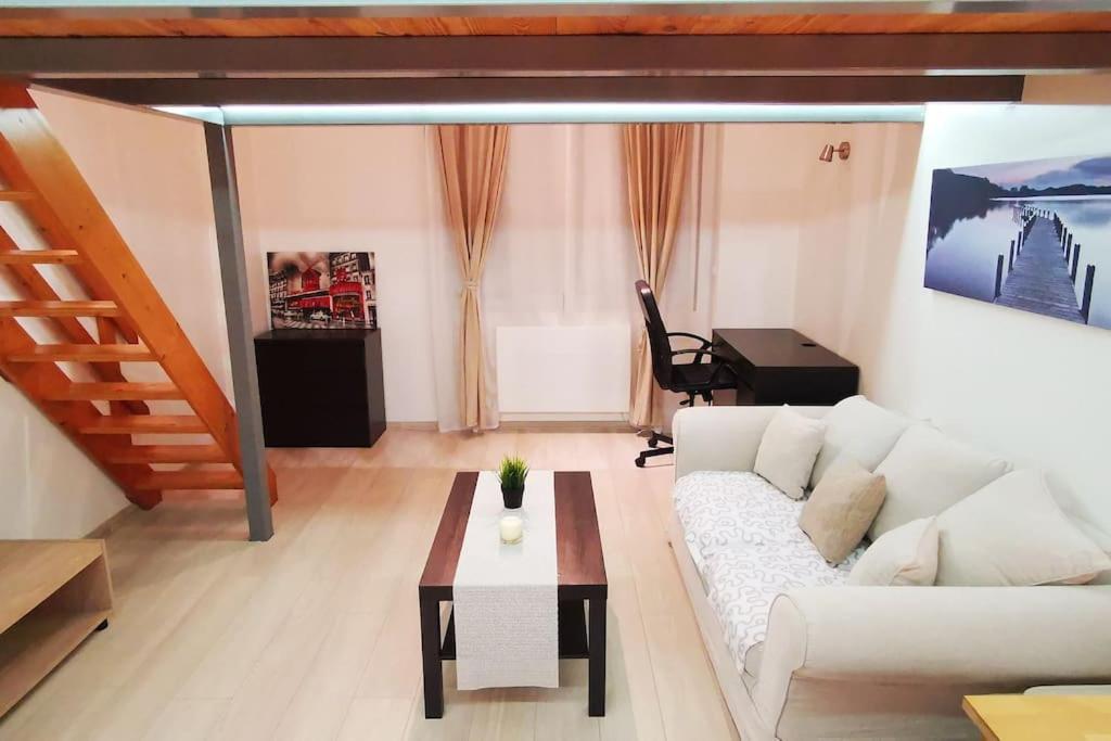 un salon avec un canapé blanc et une table dans l'établissement Studio privé/ centre-ville/ proche du parc Walibi, à Les Avenières