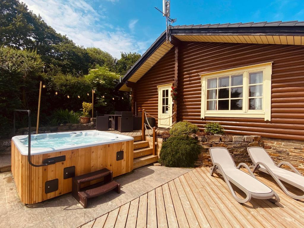 a hot tub on a deck next to a house at Faweather Grange in Bingley