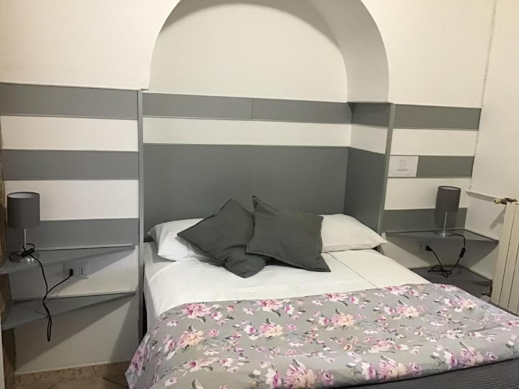 a bedroom with a bed with gray and white stripes at casa Marilena in Tivoli