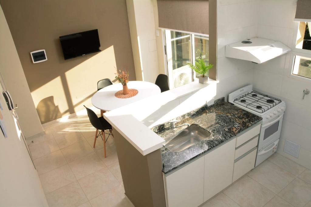 a kitchen with a sink and a stove and a table at Villa Apart Center in Villa Constitución