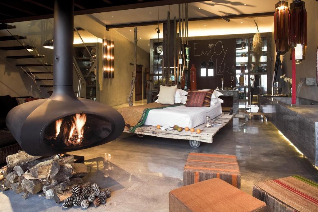 a room with a fireplace and a bed in it at Areias do Seixo Hotel in Santa Cruz