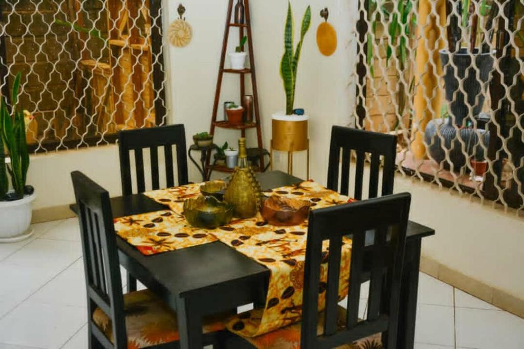 una sala da pranzo con tavolo, sedie, tavolo e sedie, e una sedia a sdraio di Naalya Motel a Kampala