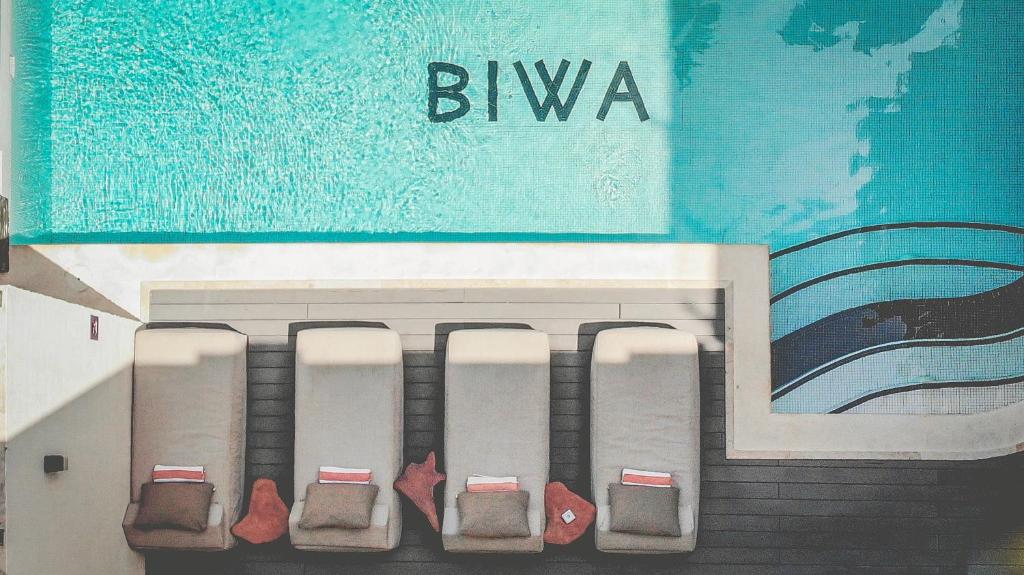a row of seats sitting on the side of a building at Biwa Tulum in Tulum